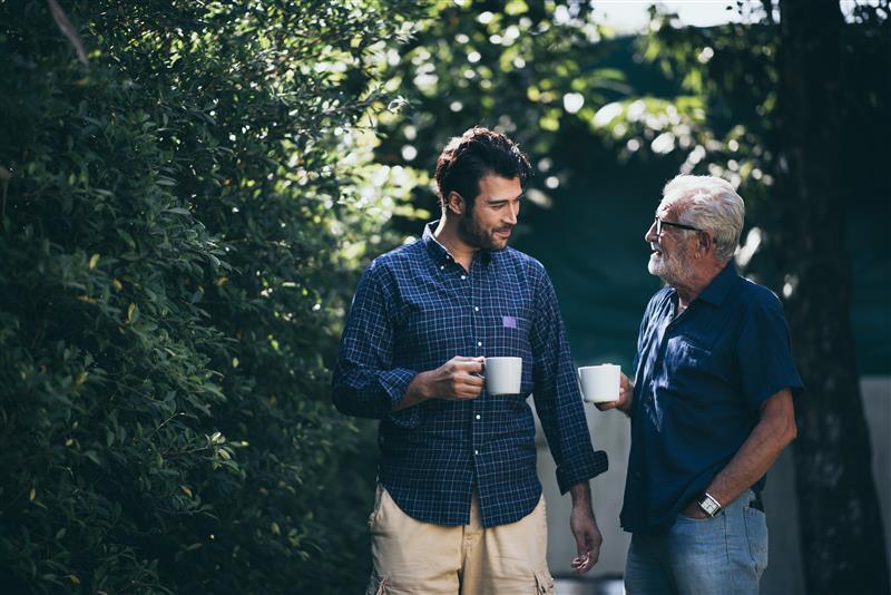 Younger man and older man talking with coffee