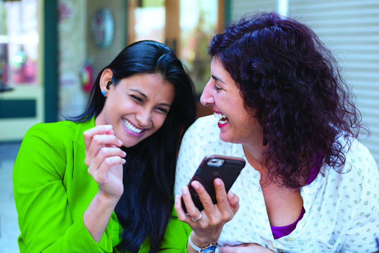 Two women discussing something on the mobile phone