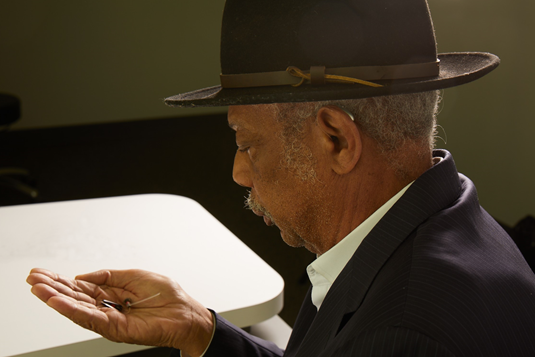 Charles Owens looking at his hearing aids