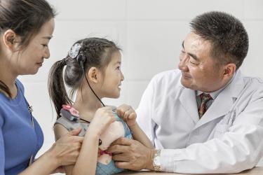 Dr. Jianxin Qiu helping patient