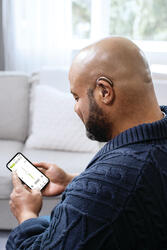 Phonak_Naida-L-PR_Man-With-myPhonak-app_LR.jpg