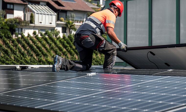 Construction worker installing solar panels